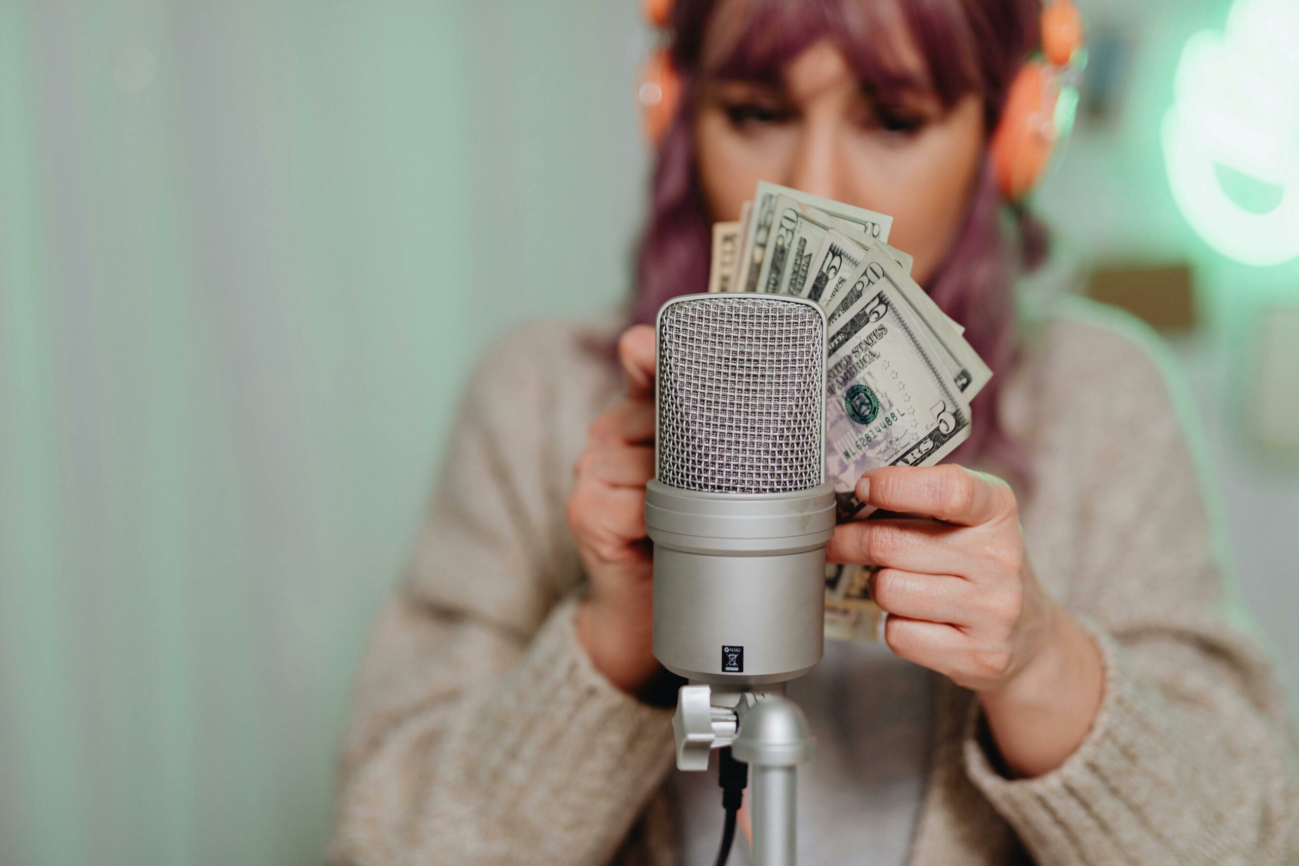 Młoda influencerka nagrywająca film lub podcast przy profesjonalnym mikrofonie.