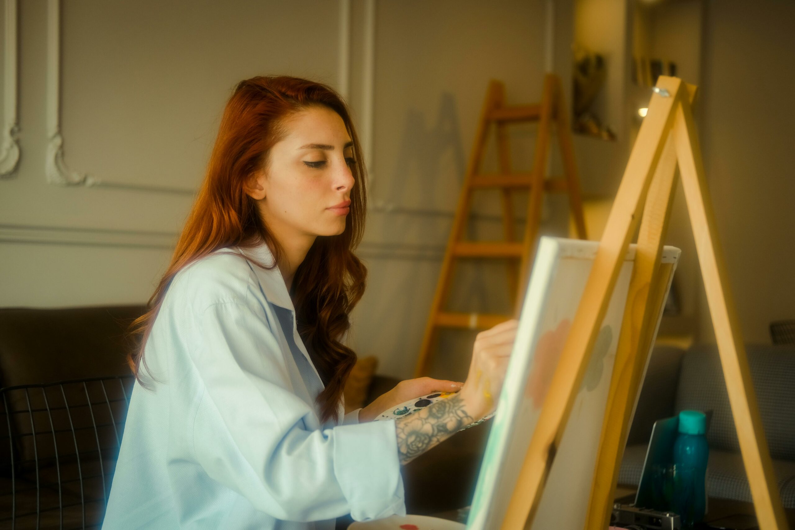 Artystka malująca obraz w atelier – promowanie sztuki online dzięki współpracy z influencerami na platformie NanoInflu.